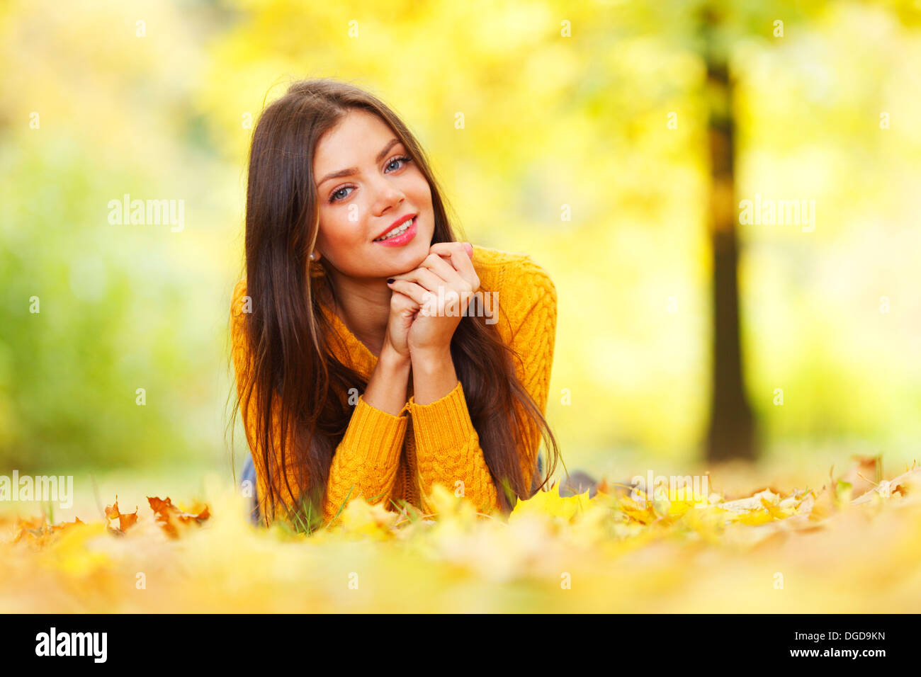 Girl laying on leafs in the autumn park Stock Photo - Alamy