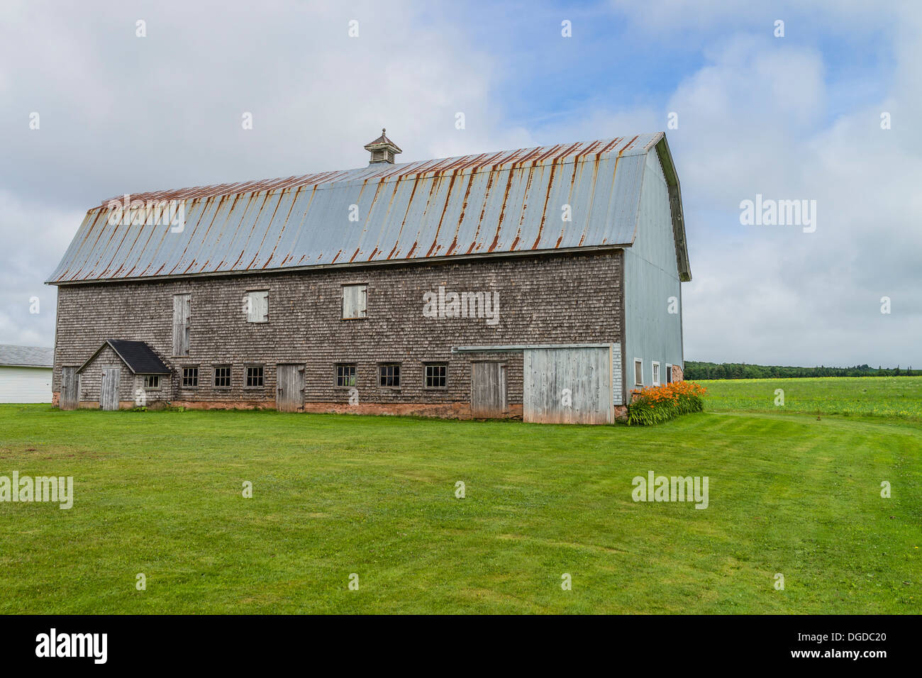 Old weathered shake shingle sided barn with rusted metal roof Prince Edward Island, one of the Maritime Provinces in Canada. Stock Photo