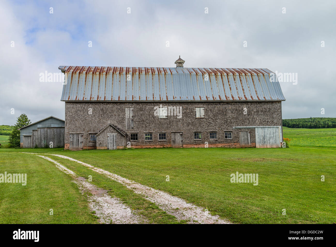 Old weathered shake shingle sided barn with rusted metal roof Prince Edward Island, one of the Maritime Provinces in Canada. Stock Photo