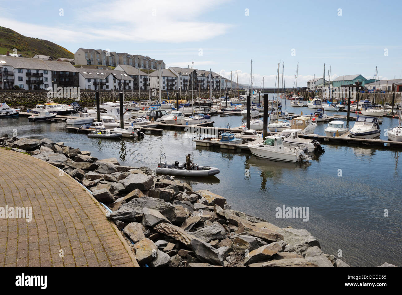 Floating pontoons with moored private leisure, pleasure boats, with waterside housing behind, Aberystwyth, Wales, UK. Stock Photo