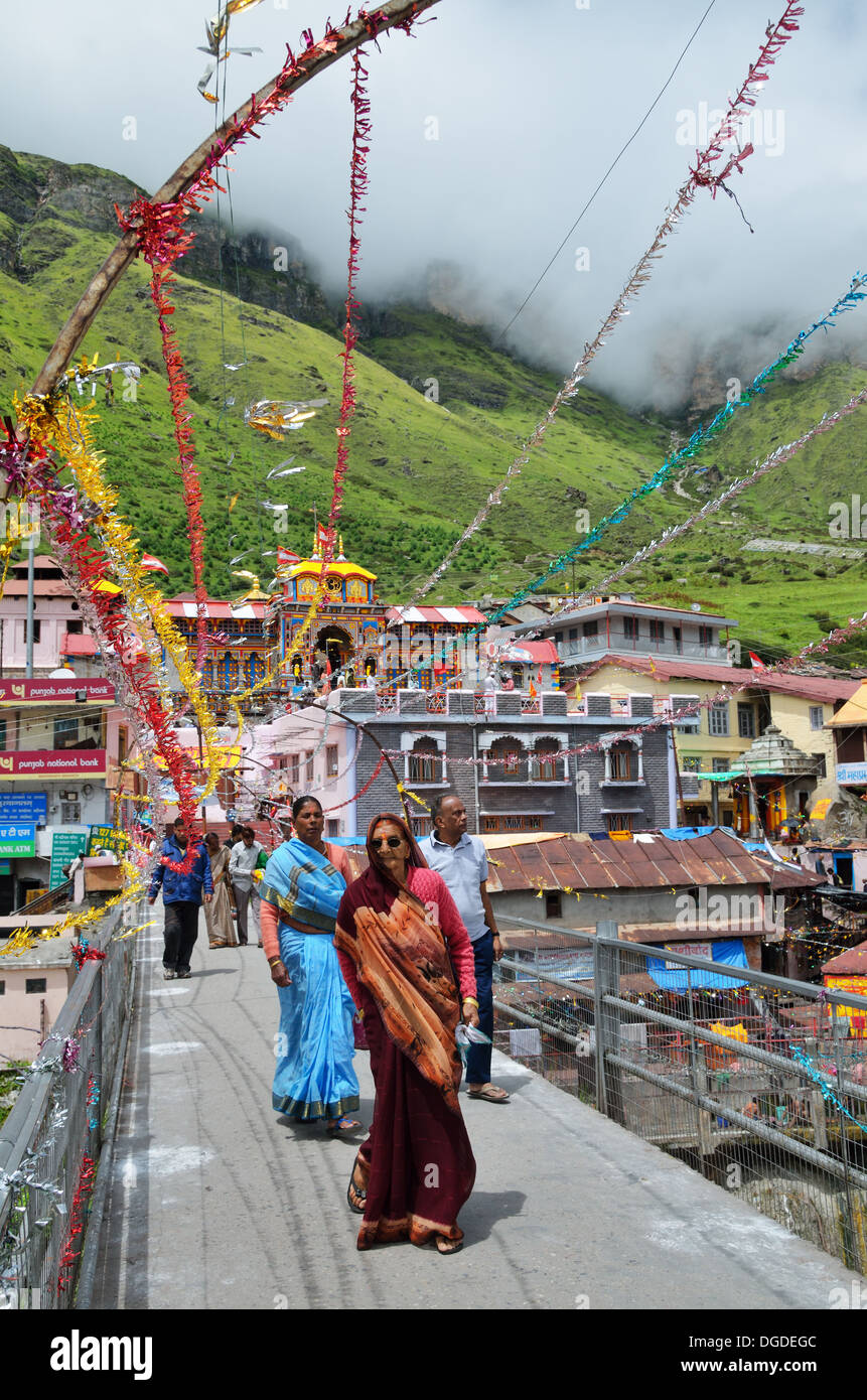 Pilgrims walking on a bridge to the Badrinath temple in the Himalayas, India Stock Photo