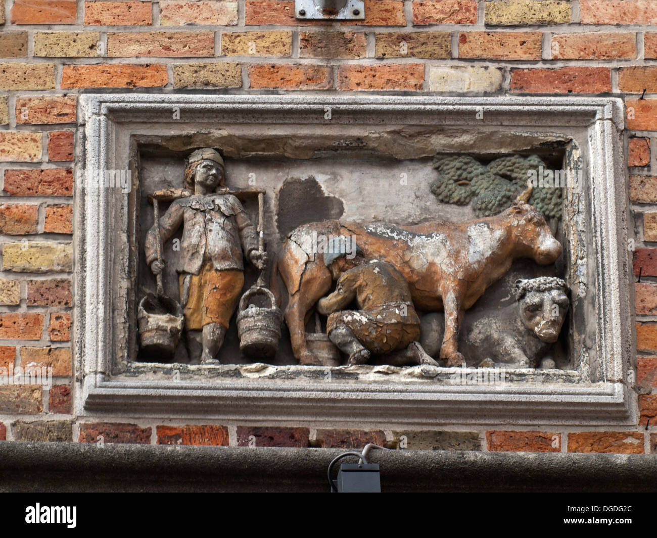 Building facade decoration with milking cow bass relief in Tanner's Square, Bruges Stock Photo