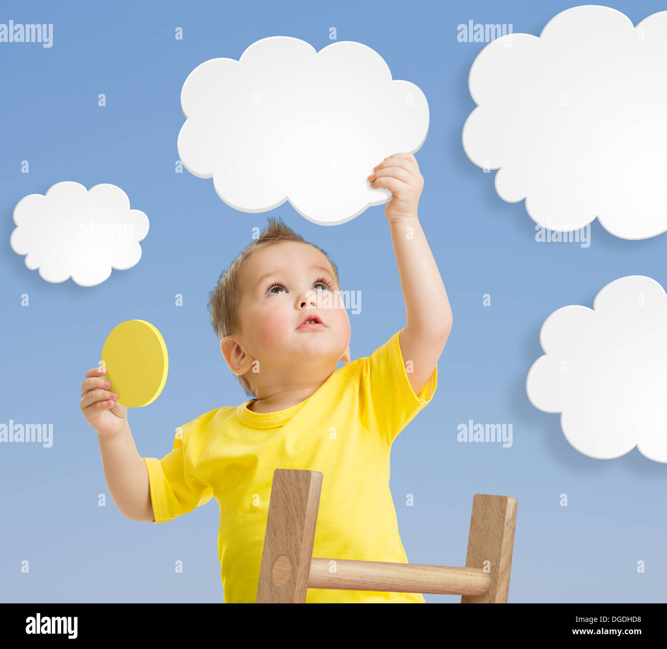 Kid on ladder holding cloud and sun Stock Photo