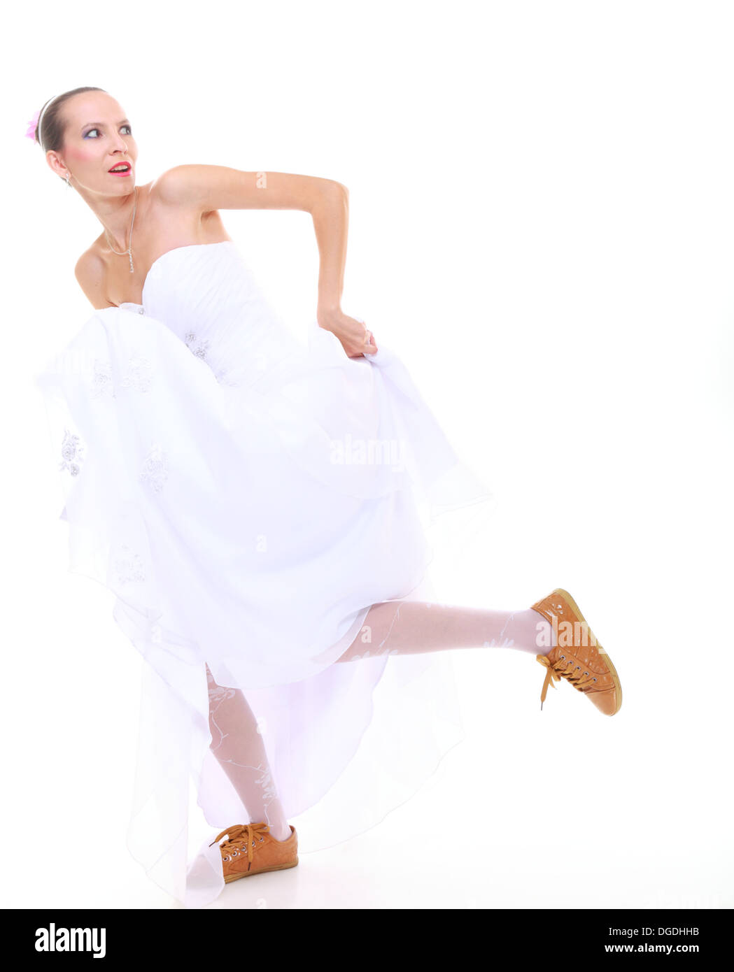 Wedding day. Running bride funny young woman wearing sporting shoes isolated on white background Stock Photo