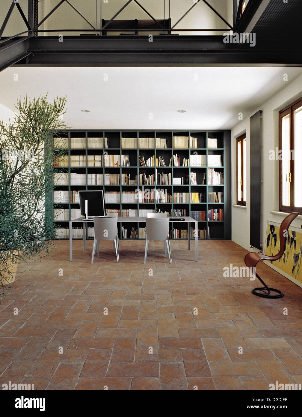 table in the meeting room with terracotta floor ad large bookcase Stock Photo