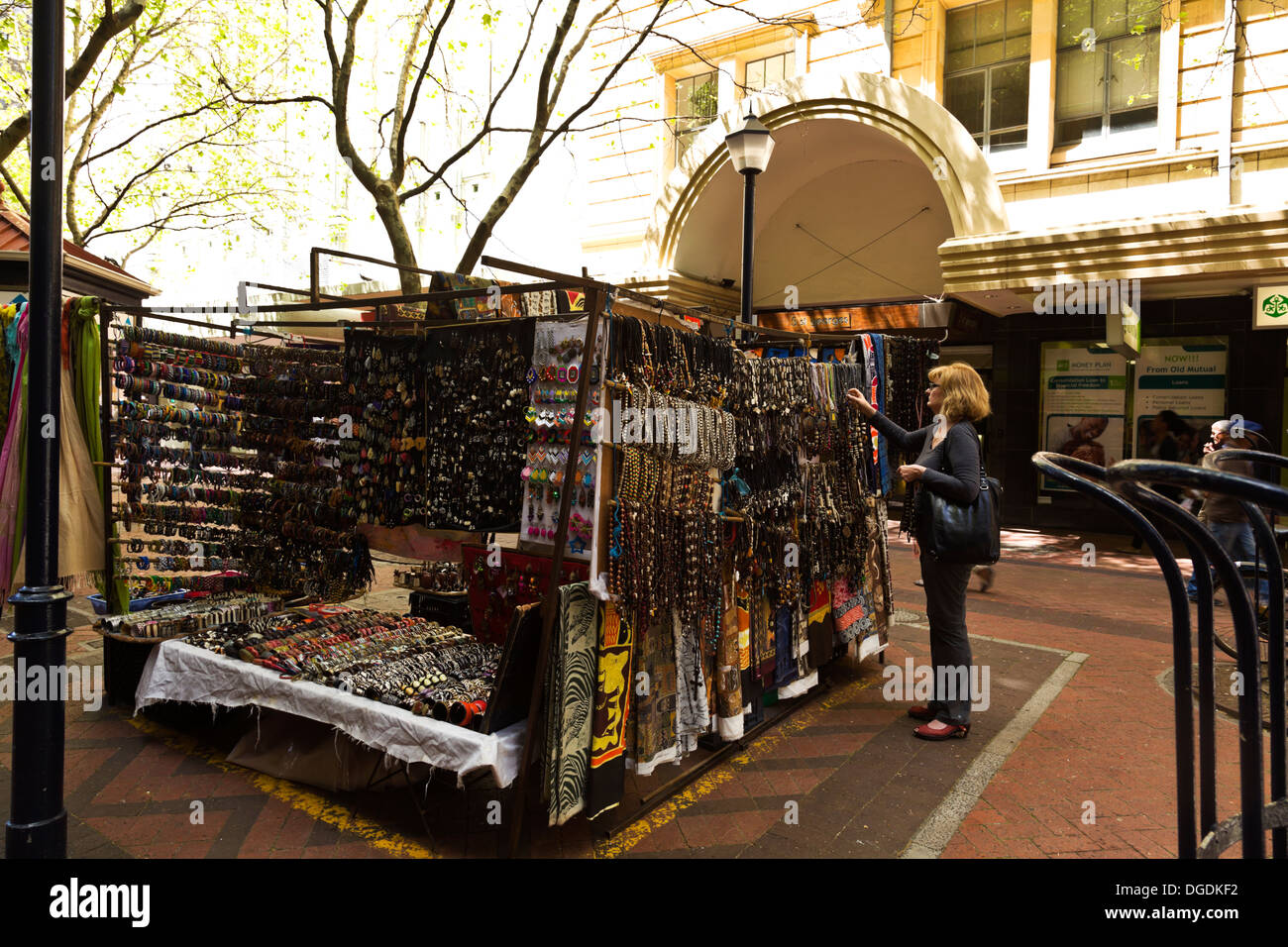 A customer looks at a selection of handicrafts on sale by a street vendor in St Georges Mall near Longmarket Street in Cape Town Stock Photo