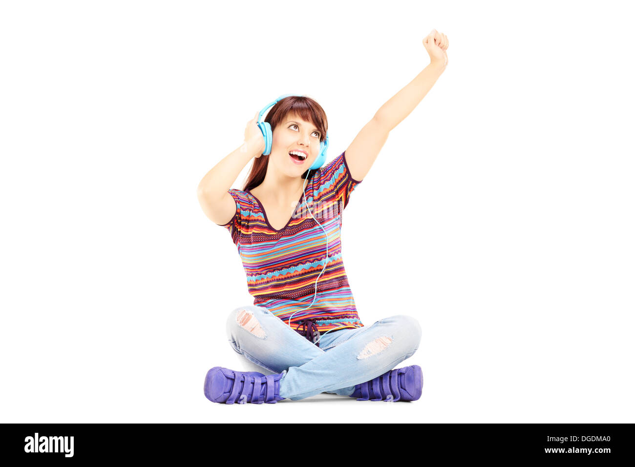 Happy female sitting on a floor and listening music Stock Photo - Alamy