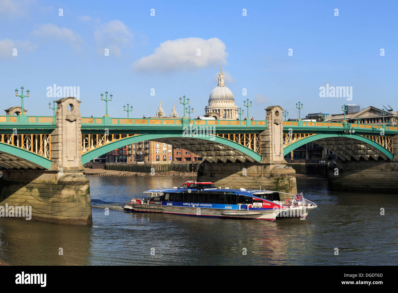 Thames Clipper river bus passes under Southwark Bridge London Stock Photo