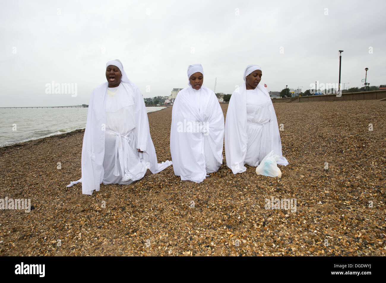 Southend, Essex, UK. 19th October 2013. On the beach at the Essex resort, dark wet weather fails to prevent prayers by the Christian Apostles. An African based religion, praying outside brings the members closer to God. Credit:  Allsorts Stock Photo/Alamy Live News Stock Photo