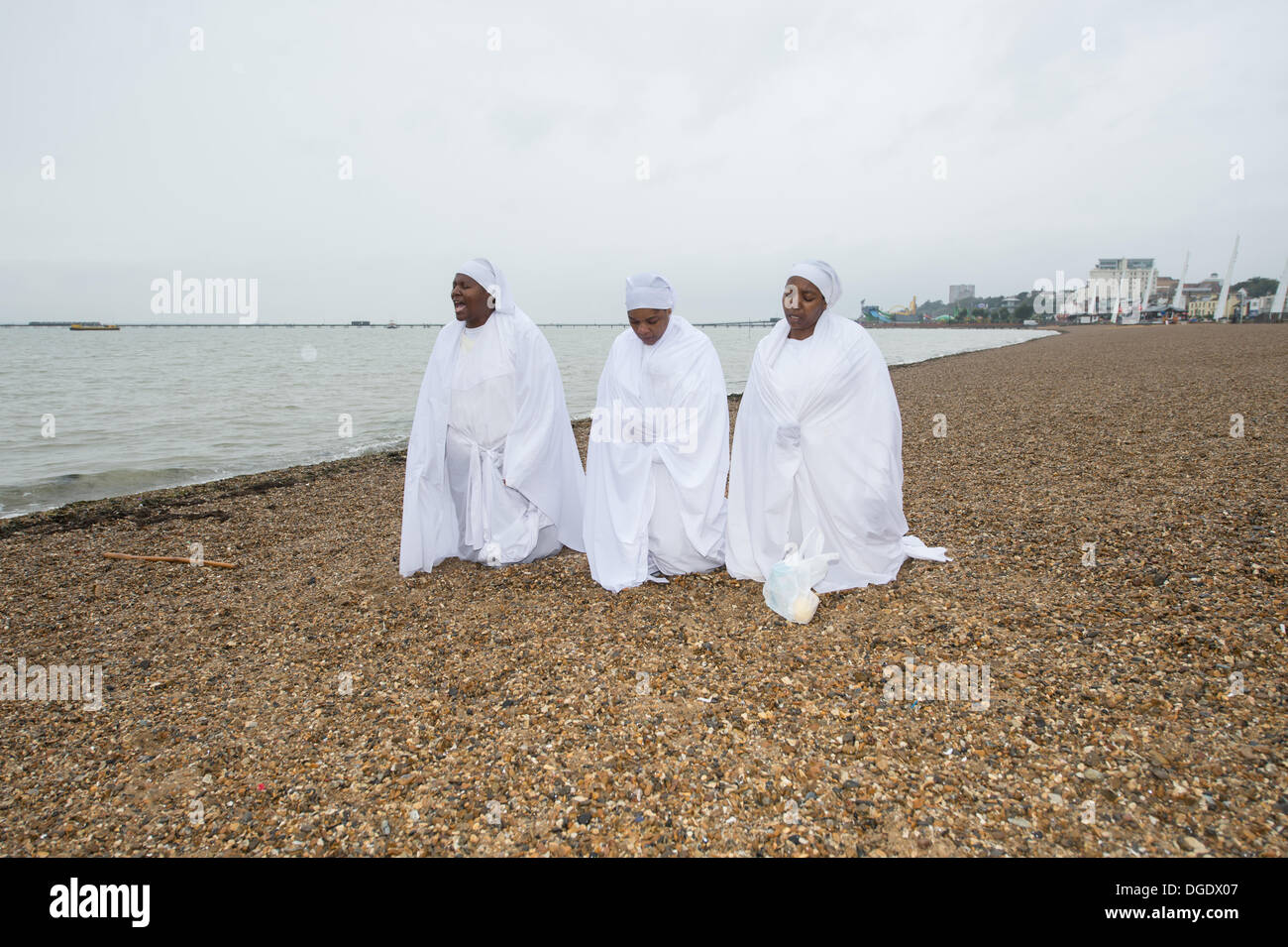 Southend, Essex, UK. 19th October 2013. On the beach at the Essex resort, dark wet weather fails to prevent prayers by the Christian Apostles. An African based religion, praying outside brings the members closer to God. Credit:  Allsorts Stock Photo/Alamy Live News Stock Photo