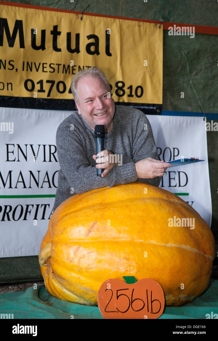 Giant Pumpkin Competition  Southport, UK.  19th October, 2013. Mr Dave Turley, compere, with his entry at the Mere Brow Giant Pumpkin Competition.  The event marks the 19th year of the event and as always raises as much money as possible for charity. HUGE pumpkins were on display at the annual celebration of the popular vegetable.  Mere Brow is a small village in Lancashire, England, situated between Tarleton and Banks. Stock Photo