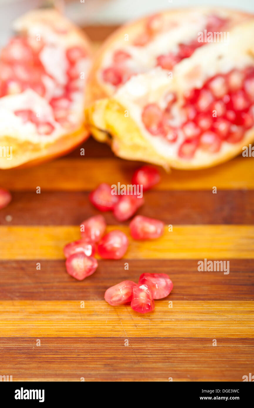 fresh pomegranate fruit over wood cutting board Stock Photo