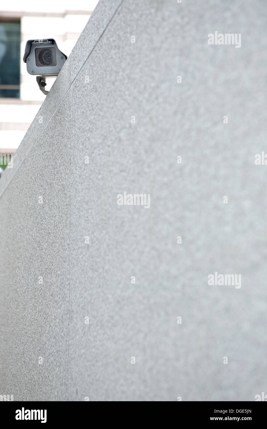 CCTV camera sitting on top of a big empty wall Stock Photo