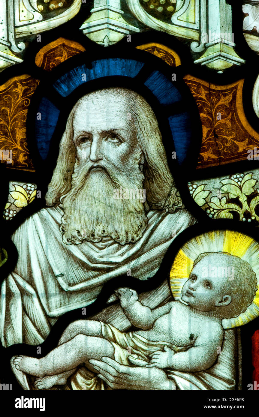 Bearded St Simeon in stained glass with blue halo holding Jesus Christ babe in arms with golden halo Seend Church Wiltshire UK Stock Photo