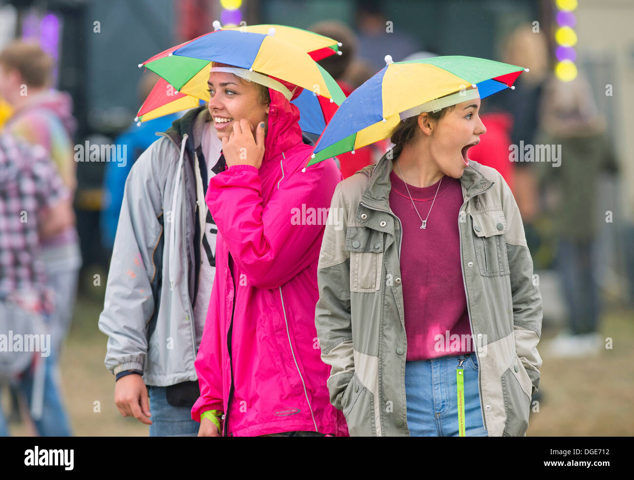 The Reading Festival - girls with umbrella hats head for the main stage Aug 2013 Stock Photo