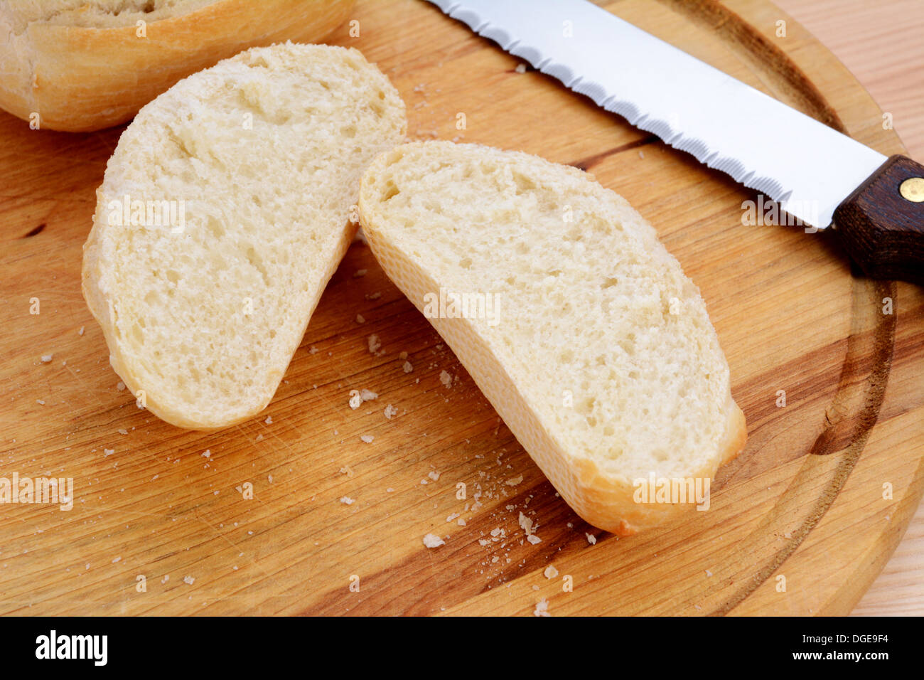 Closeup of a freshly cut bread roll on a cutting board Stock Photo