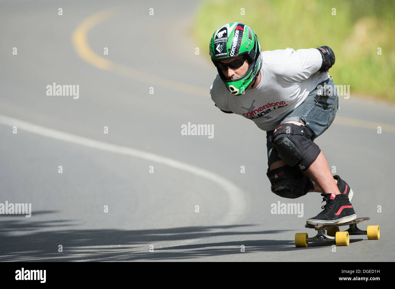 skateboard longboard man training downhill on public road Stock Photo