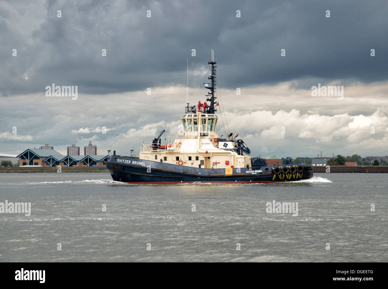 Svitzer Brunel a modern tug boat makes her backwards downstream on the River Thames at Tilbury East of London City Stock Photo