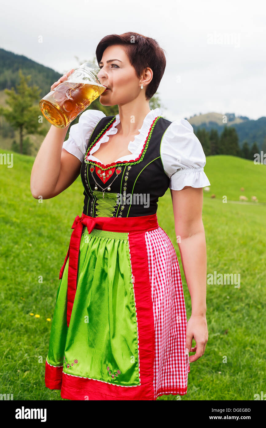 Beautiful girl in a dirndl drinking beer Stock Photo