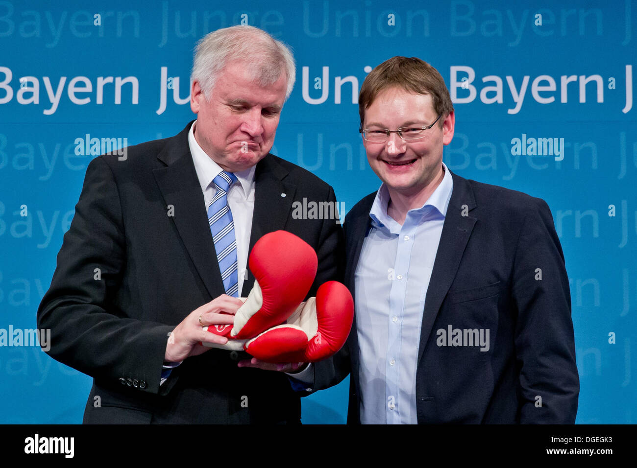 Nuremberg, Germany. 19th Oct, 2013. The new chairman of the Young Union in Bavaria, Hans Reichhart (R), presents a boxing gloves to Bavarian Premier Horst Seehofer at the Young Union party meeting in Nuremberg, Germany, 19 October 2013. Photo: Daniel Karmann/dpa/Alamy Live News Stock Photo