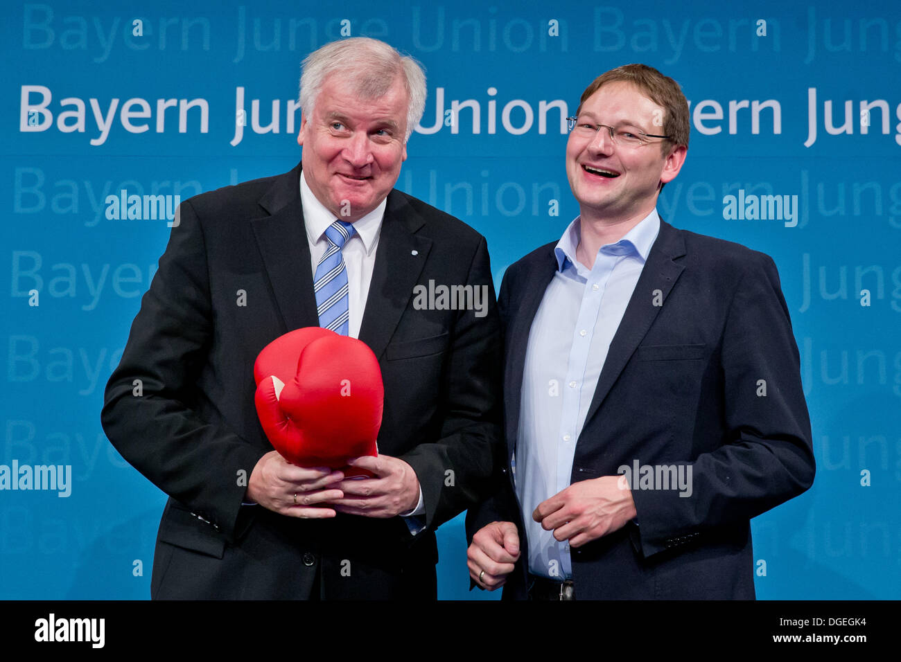 Nuremberg, Germany. 19th Oct, 2013. The new chairman of the Young Union in Bavaria, Hans Reichhart (R), presents a boxing gloves to Bavarian Premier Horst Seehofer at the Young Union party meeting in Nuremberg, Germany, 19 October 2013. Photo: Daniel Karmann/dpa/Alamy Live News Stock Photo