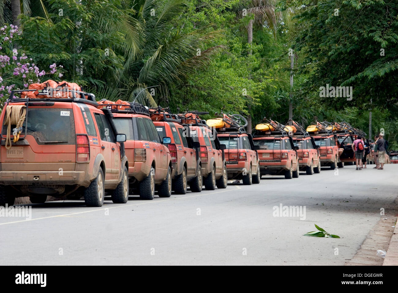 Vehicles taking part in the Land Rover G4 Challenge are parked on a city street in Luang Prabang, Laos. Stock Photo