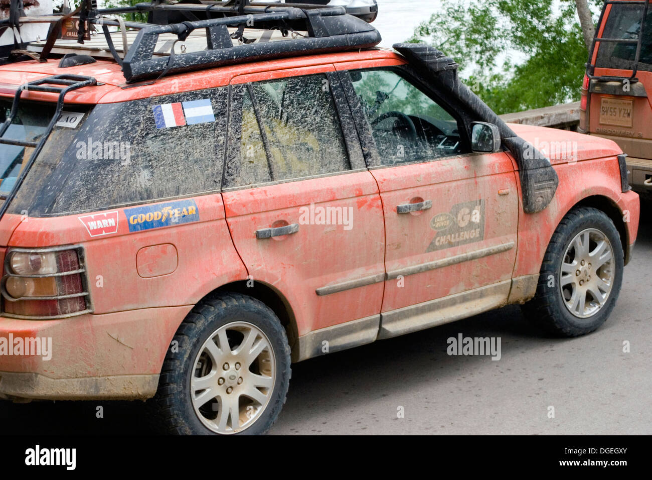 A vehicle taking part in the Land Rover G4 Challenge is splatterd with mud on a city street in Luang Prabang, Laos. Stock Photo