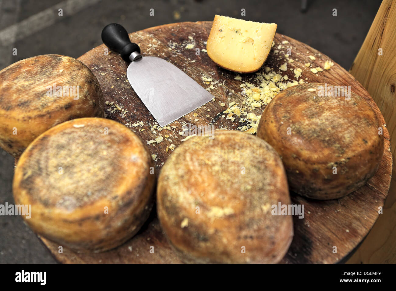 Small wheels of pecorino and cheese knife on wooden table. Stock Photo