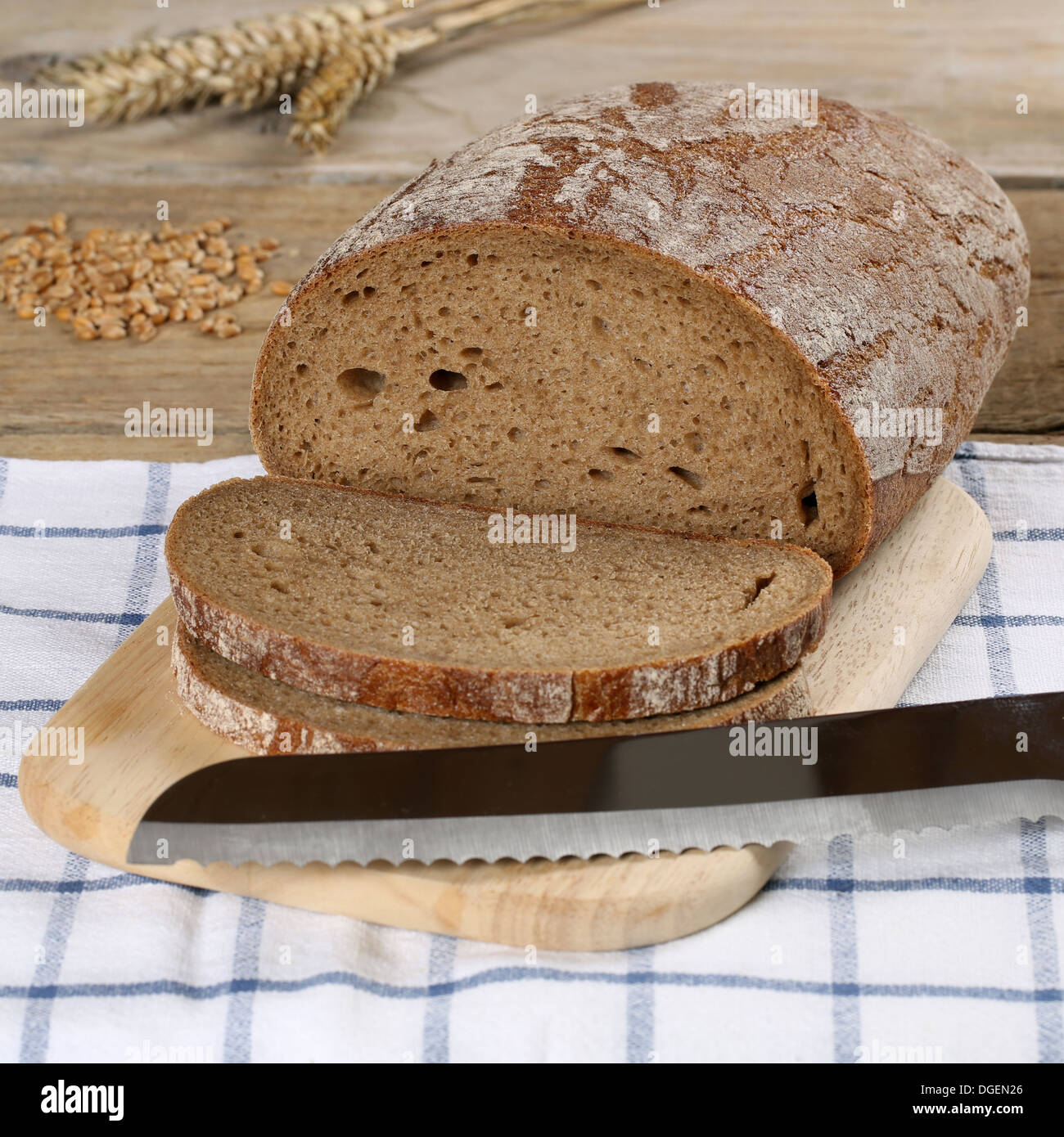 Sliced wheat bread on a wooden board and a bread knife Stock Photo