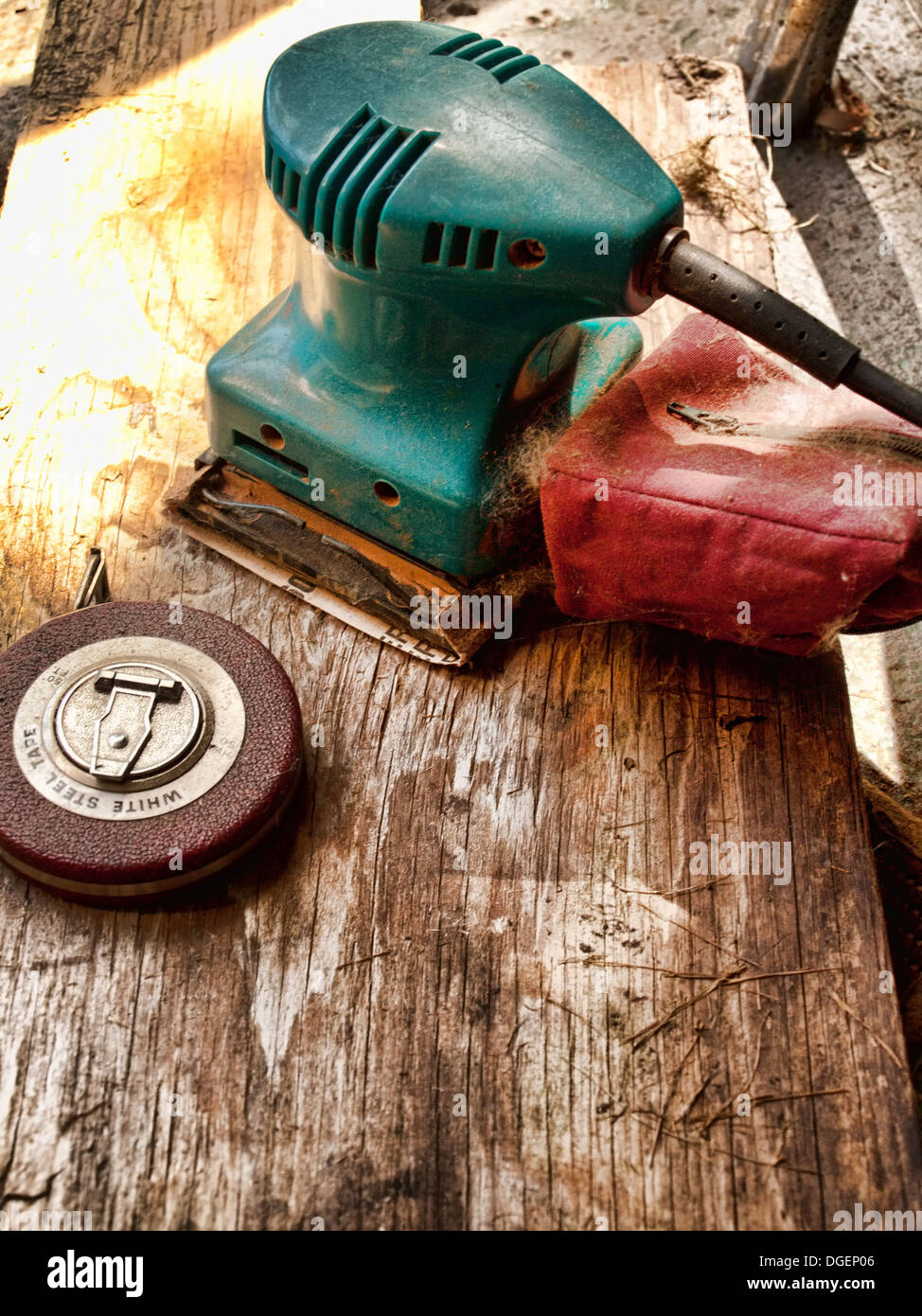 old, dusty tape measure and electric wood sander Stock Photo Alamy