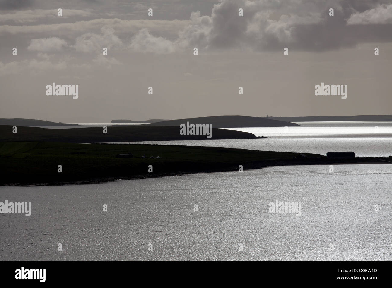 Islands of Orkney, Scotland. Silhouetted view over the Orkney islands of Lamb Holm and Burray towards South Ronaldsay and Flotta Stock Photo