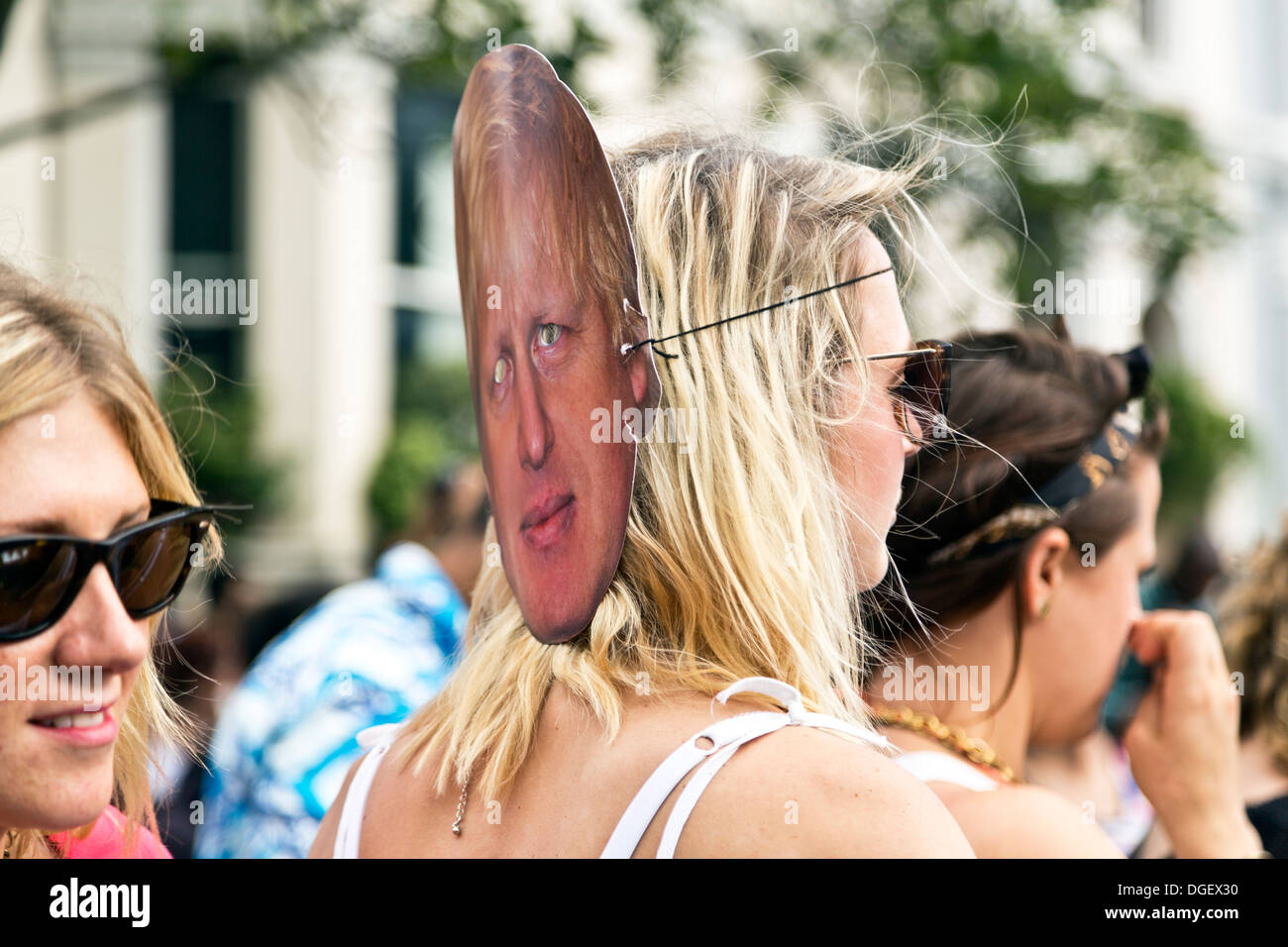 Young woman wearing a Boris Johnson face mask behind her head at the Notting Hill Carnival 2013, London, England Stock Photo