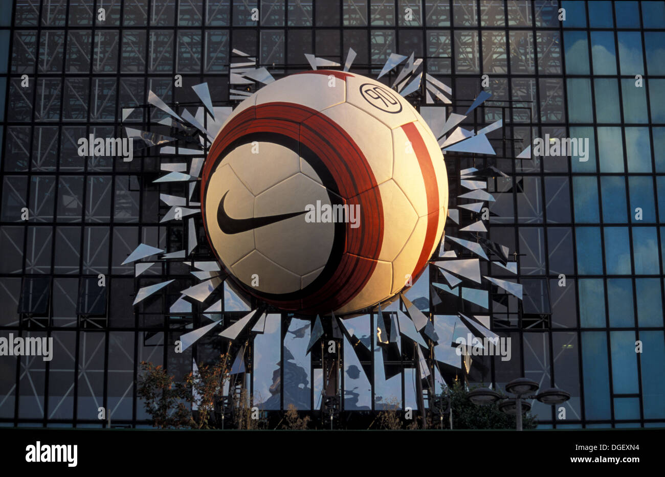 Nike Advertisement of a giant football ball simulating breaking the glasses  of a building in La Defense, Paris Stock Photo - Alamy