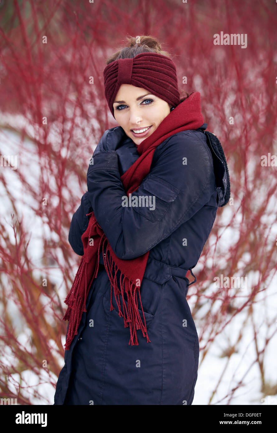 Shivering woman with red scarf in a cold winter park Stock Photo