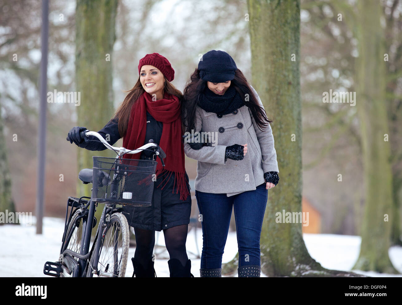 Two beautiful women having fun together on a chilly day at the park Stock Photo