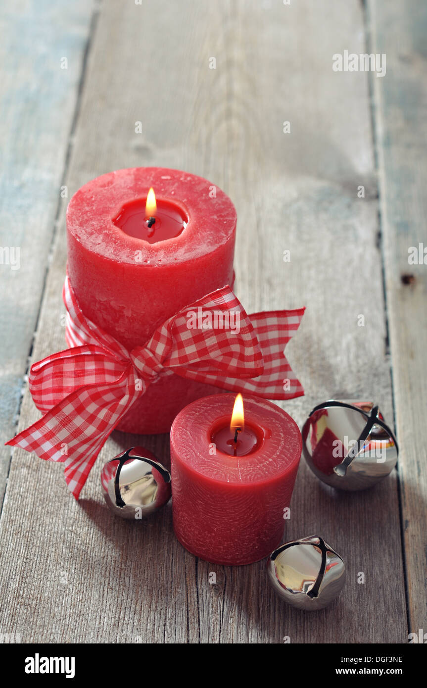 Two red candles with christmas decor on wooden background Stock Photo