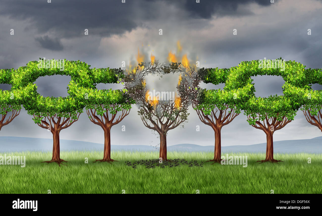 Chain breaking business concept with a group of linked trees shaped as connected links that are being broken and detached with a burning fire as a metaphor for ruptured network problems on a storm sky. Stock Photo