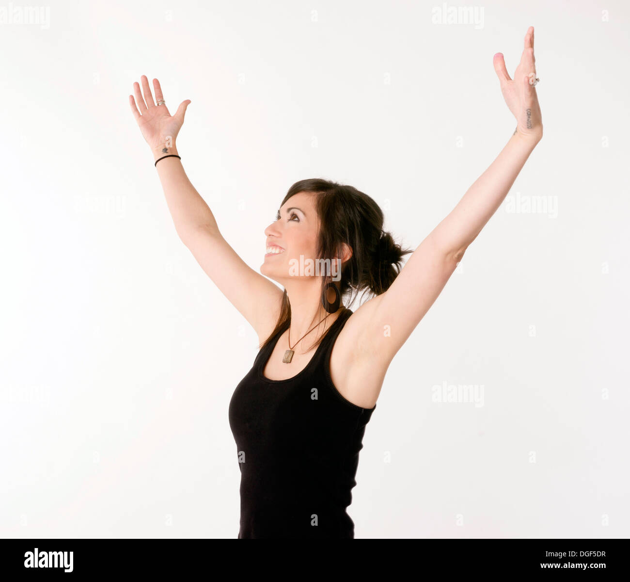 Woman motions towards the sky arms outstretched Stock Photo