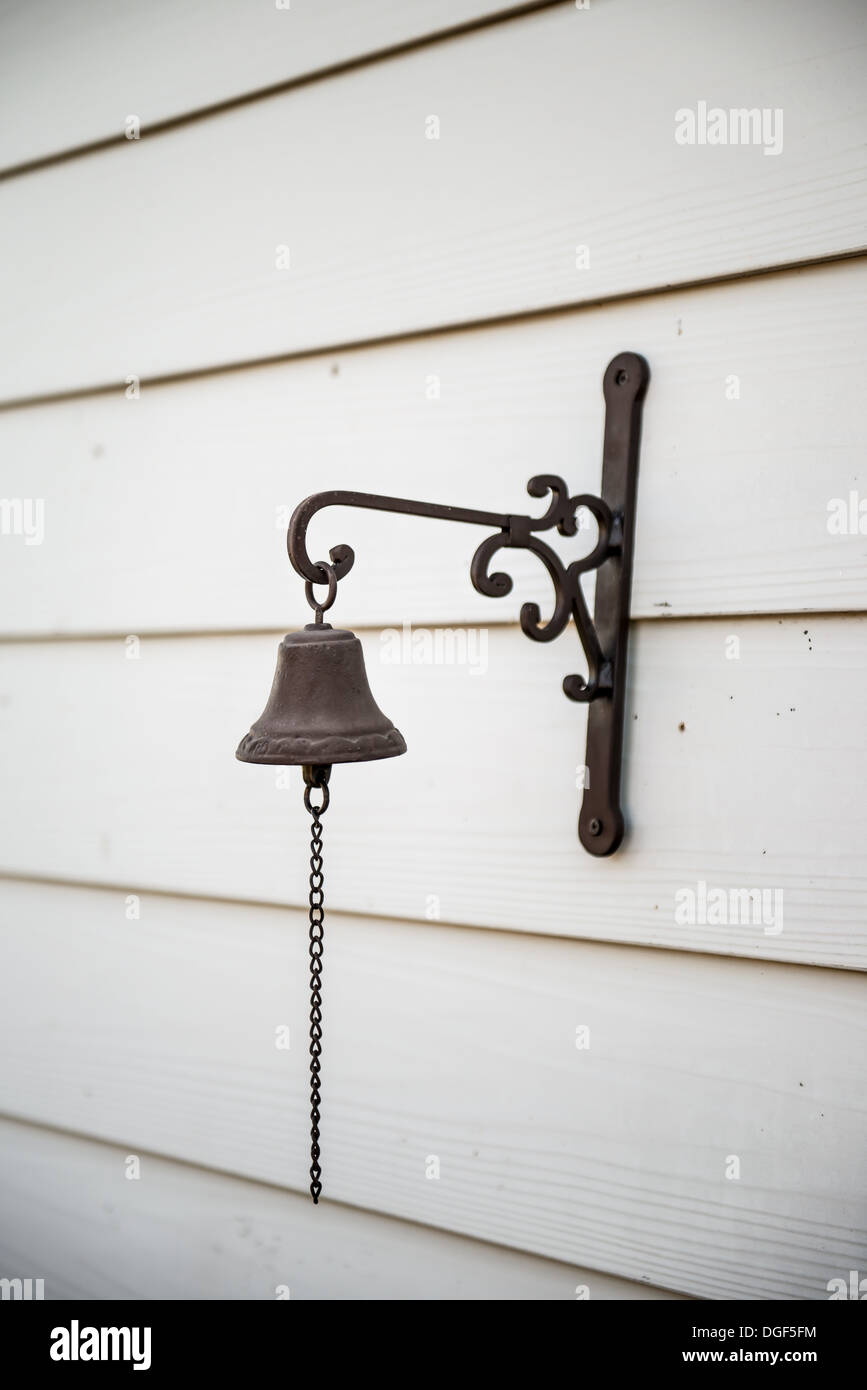 Bell and chain on a white wooden plank wall Stock Photo