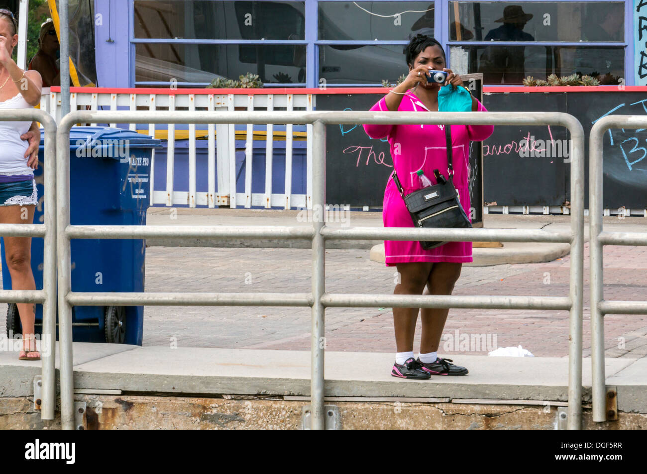 Black woman taking scenic picture with small compact point and shoot ...
