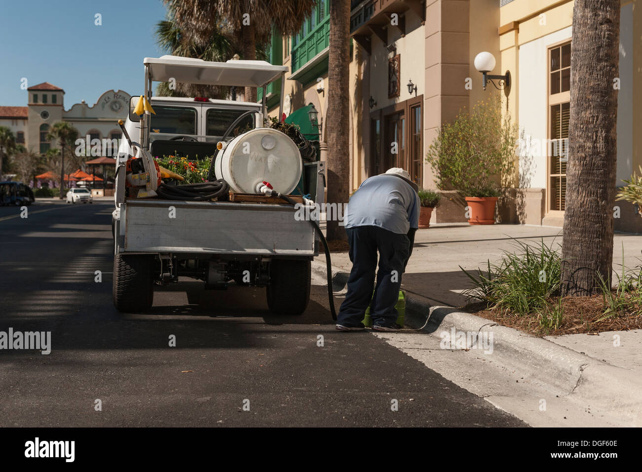 A service worker watering plants at The Villages, Florida. A golf retirement community for adults 55 and above. Stock Photo