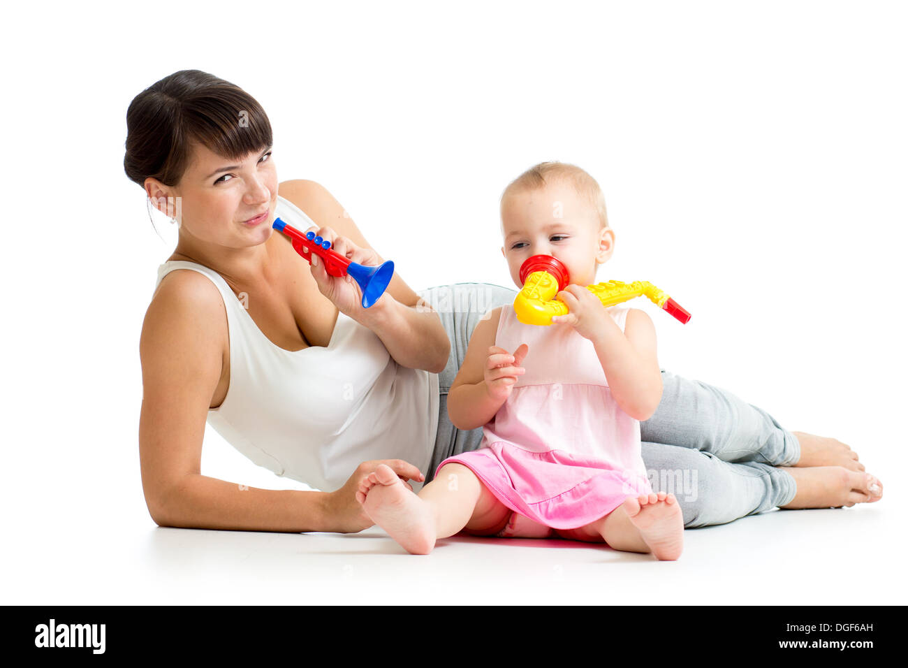 Mother and baby girl having fun with musical toys. Isolated on white background Stock Photo