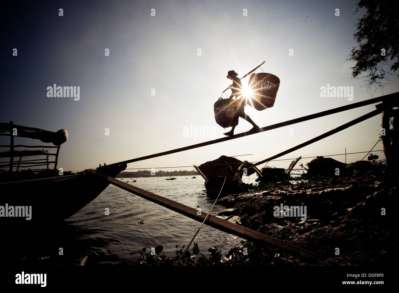 man loading a boat in the mekong delta vietnam Stock Photo - Alamy