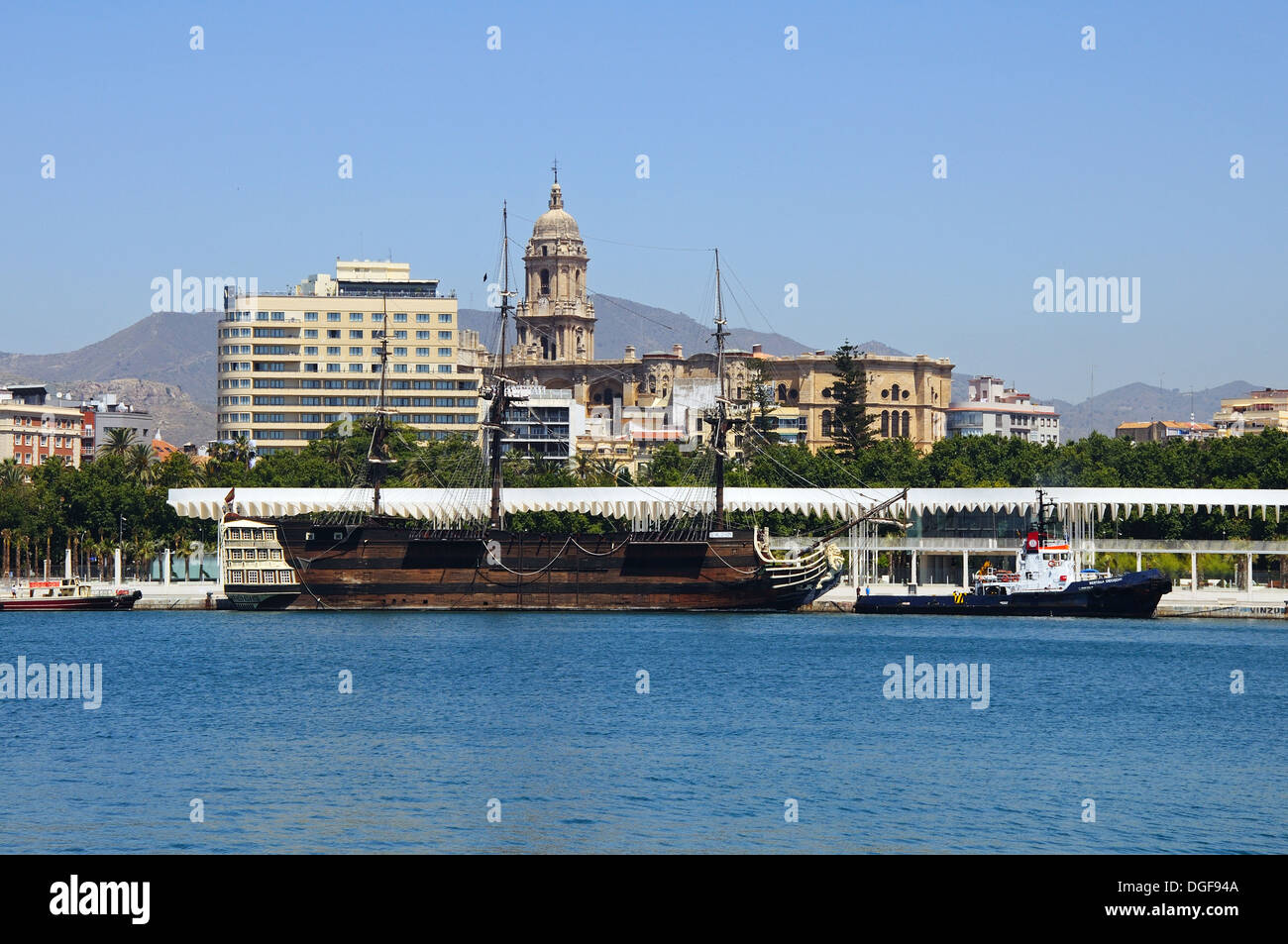 Replica of the Santisima Trinidad in the Inner harbour with the Cathedral (Catedral la Manquita) to the rear, Malaga, Spain. Stock Photo