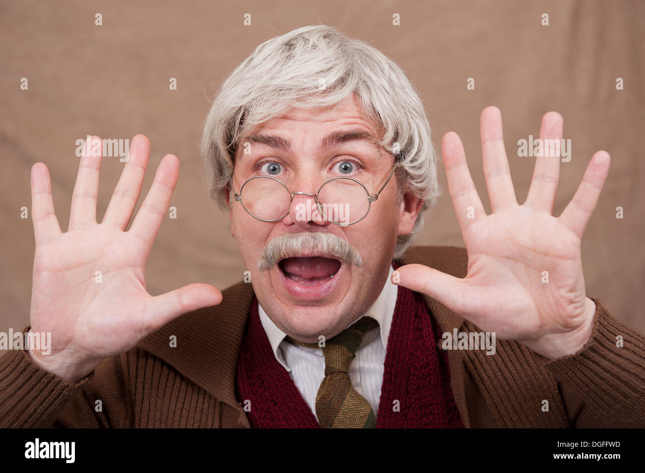 Grey haired old mouth with mouth wide open and with both hands open towards camera. Stock Photo