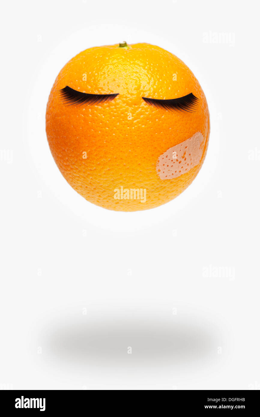 an image of an orange having fake eye lashes Stock Photo