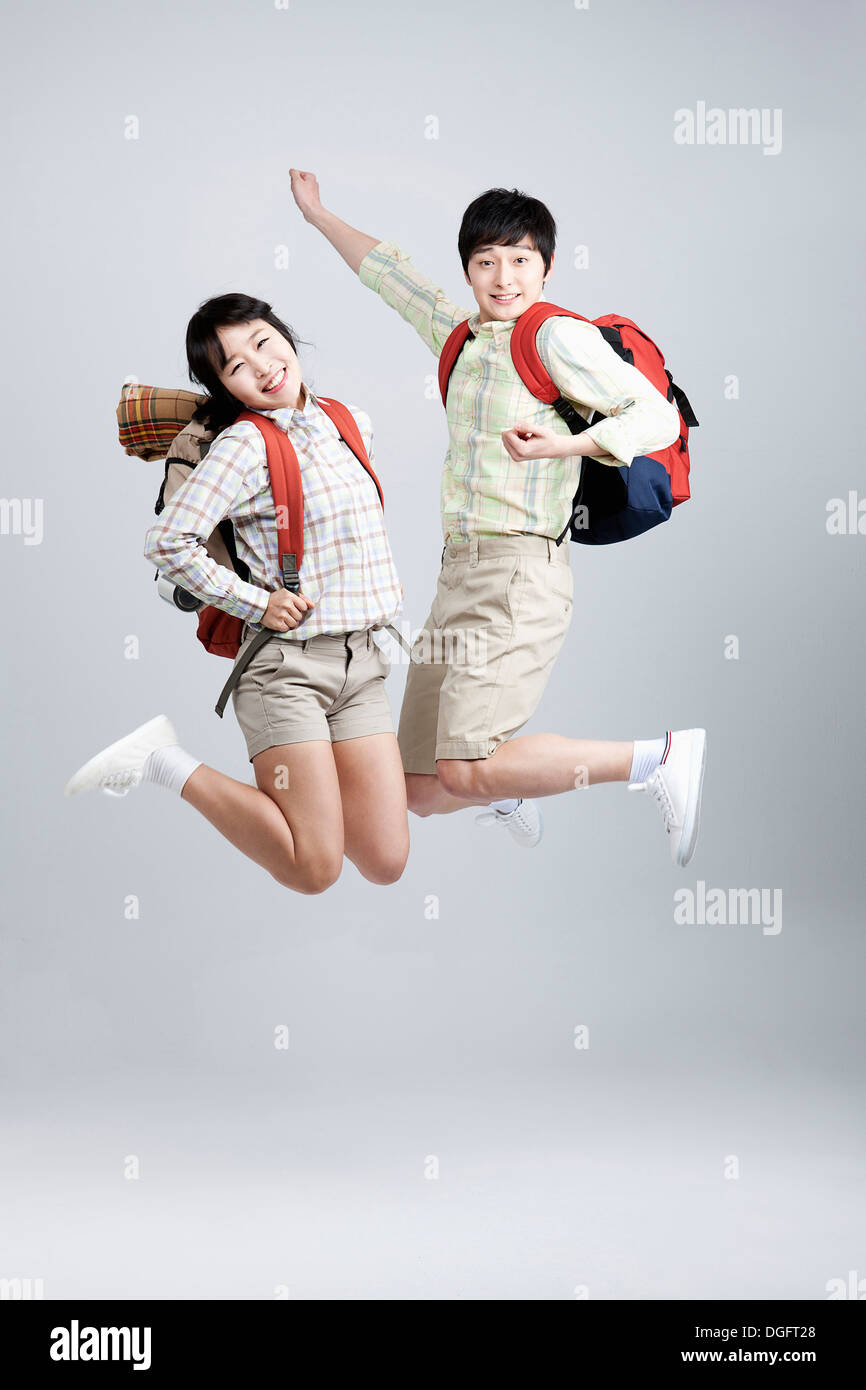 a couple with hiking gear jumping Stock Photo Alamy