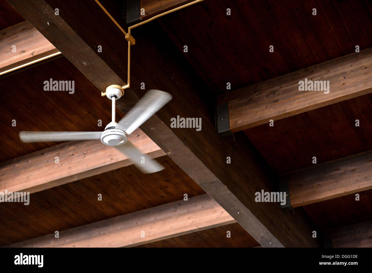 Wooden ceiling with a rotating ceiling fan Stock Photo