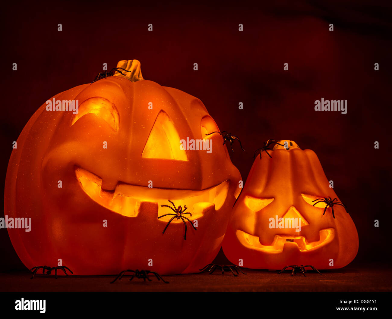 Scary glowing pumpkin with creepy spiders on dark red background ...
