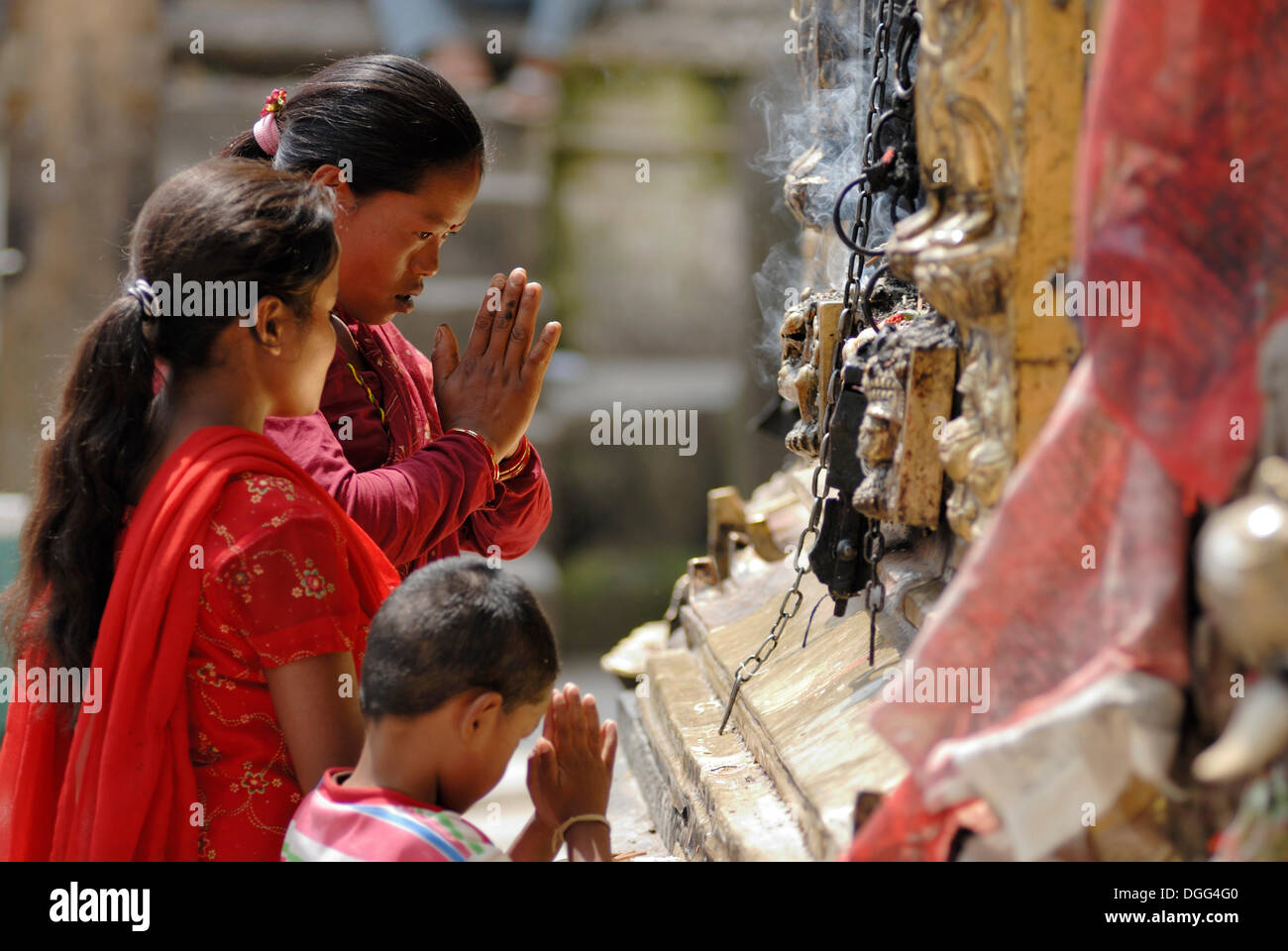 Praying women with a child, Swayambunath Temple, Kathmandu, Nepal, Asia Stock Photo